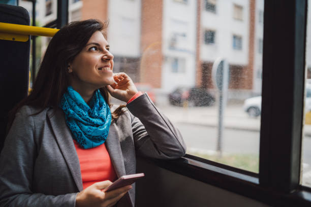 Young woman using phone on a city bus ride