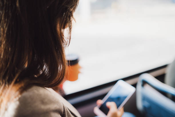 istock Young woman using phone on a city bus ride 1063824714