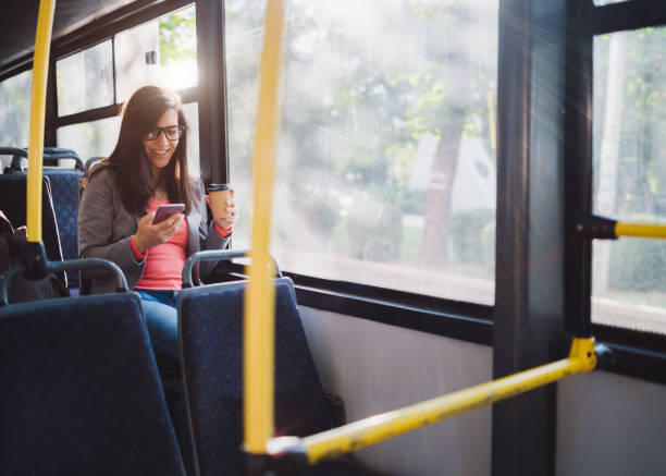 istock Young woman using phone on a city bus ride 1063824780