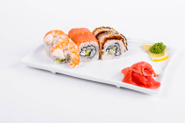 istock Asian food. Tokyo rolls with shrimp, eel and salmon on a white plate on a white background 1063824924