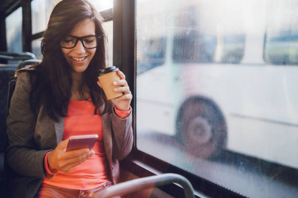 Young woman using phone on a city bus ride