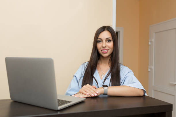 istock beutiful young woman administrator on reception working at laptop. 1063828582
