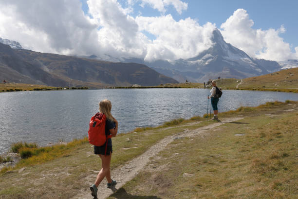 istock Female hikers walk along lakeshore 1063833312