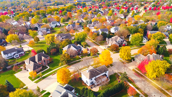 Breathtaking aerial view of idyllic neighborhoods richly colored with colorful Autumn trees.