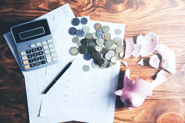 istock Broken piggy bank with coins on document 1063839684