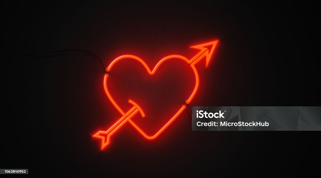 Heart And Arrow Shaped Red Neon Light On Black Wall - Valentines Day And Cupid Concept Heart and arrow shaped red neon light on black wall. Horizontal composition with copy space. Great use for Valentines Day and Cupid concepts. Cupid Stock Photo