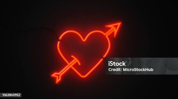 Heart And Arrow Shaped Red Neon Light On Black Wall Valentines Day And Cupid Concept Stock Photo - Download Image Now