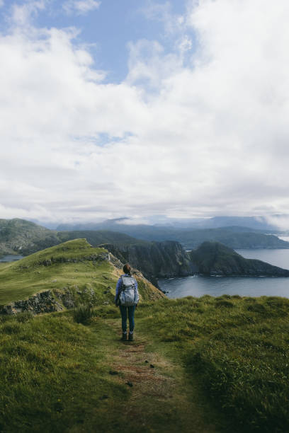 Woman with backpack hiking on Runde island in Norway