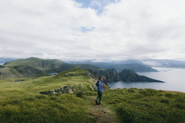 istock Woman with backpack hiking on Runde island in Norway 1063842826