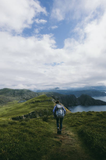 istock Woman with backpack hiking on Runde island in Norway 1063842828