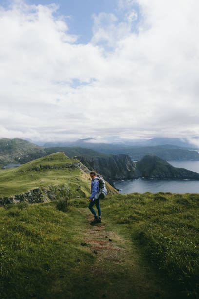 istock Woman with backpack hiking on Runde island in Norway 1063842882