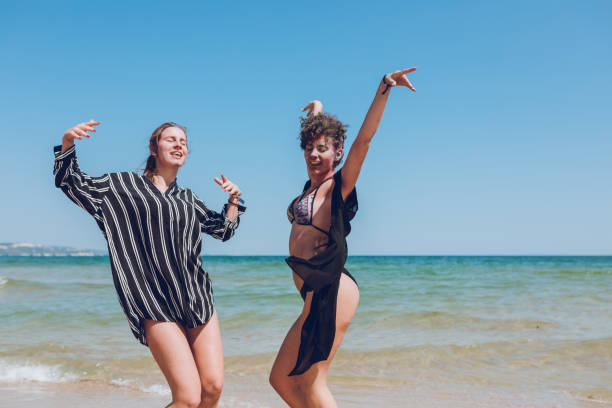istock Two young women dancing on the beach 1063844072