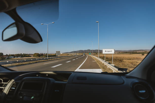 istock Man driving pass a airport sign 1063846836