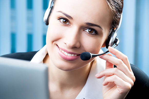 Support phone operator in headset at workplace stock photo