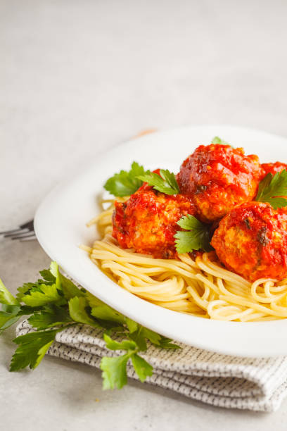 istock Pasta with chicken meatballs in tomato sauce in a white plate, copy space. 1063862002