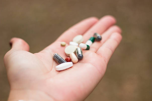divers médicaments en main de l’homme - vitamin pill flash photos et images de collection
