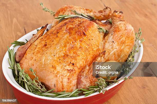 Closeup Of A Whole Turkey Roasted In Red Dish With Garnish Stock Photo - Download Image Now