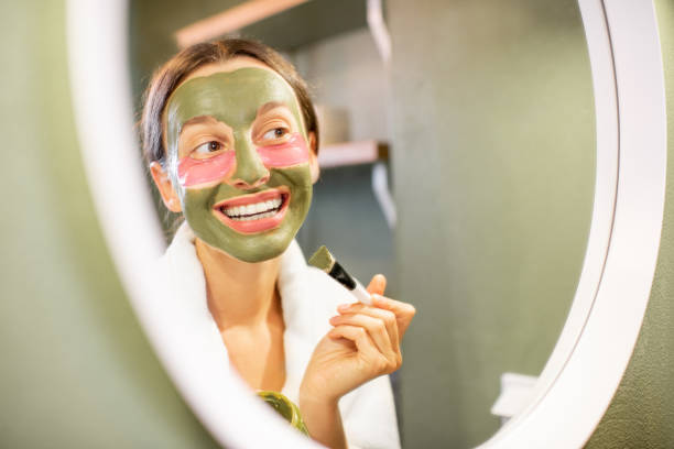 istock Woman applying mask on her face in the bathroom 1063864874