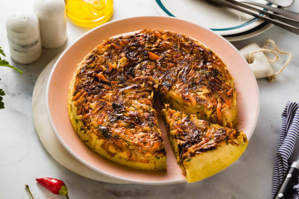 istock savory salty  Upside-Down pie from white cabbage, carrots and onions. gluten free no eggs , with chickpea flour. family breakfast or party snack on a white marble table 1063865684