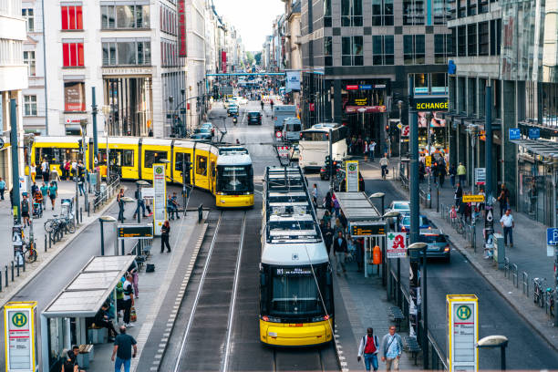 Berlin, Germany - September 16, 2018: Pedestrians and yellow tram move along Friedrichstrasse Shopping Street.
