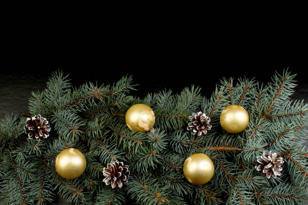 istock Christmas composition of fir branches and Christmas tree decorations a black background . Top view with copy space. 1063869632