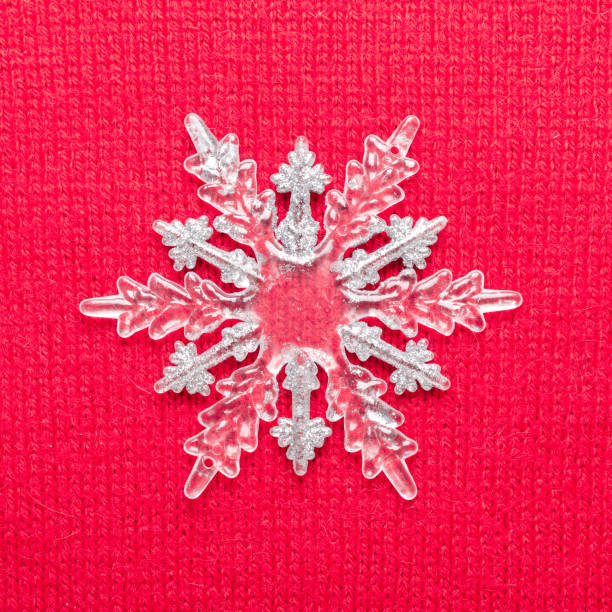 istock Christmas snowflake on red knit background. Top view 1063876746