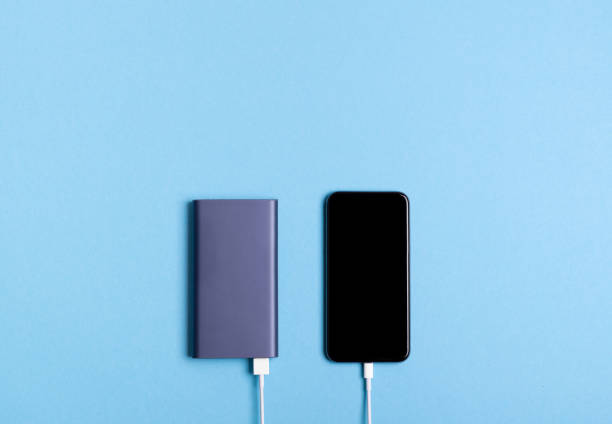 istock Smartphone charging with power bank on blue background 1063881448