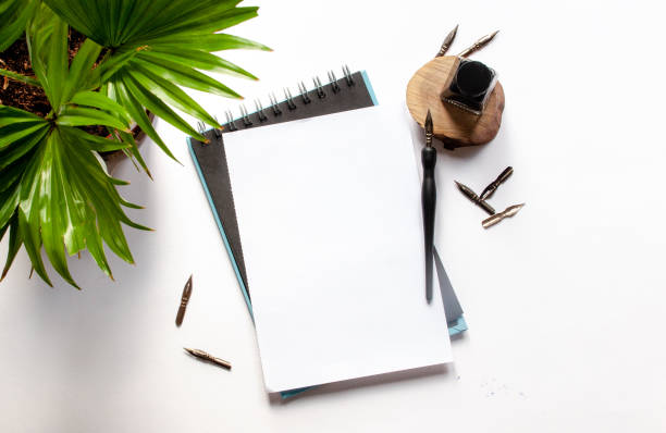 istock Black ink and ink bottle, white sheet mockup and ink pen on a white background 1063881452