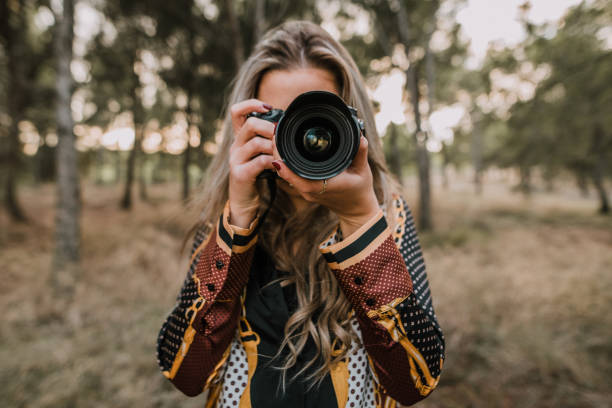 istock Young woman usign a DSLR camera 1063882384