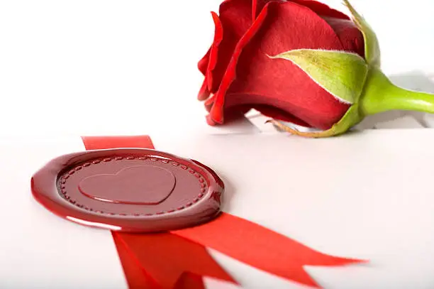 Red rose and love-letter with seal lying on keyboard, depth-of-field