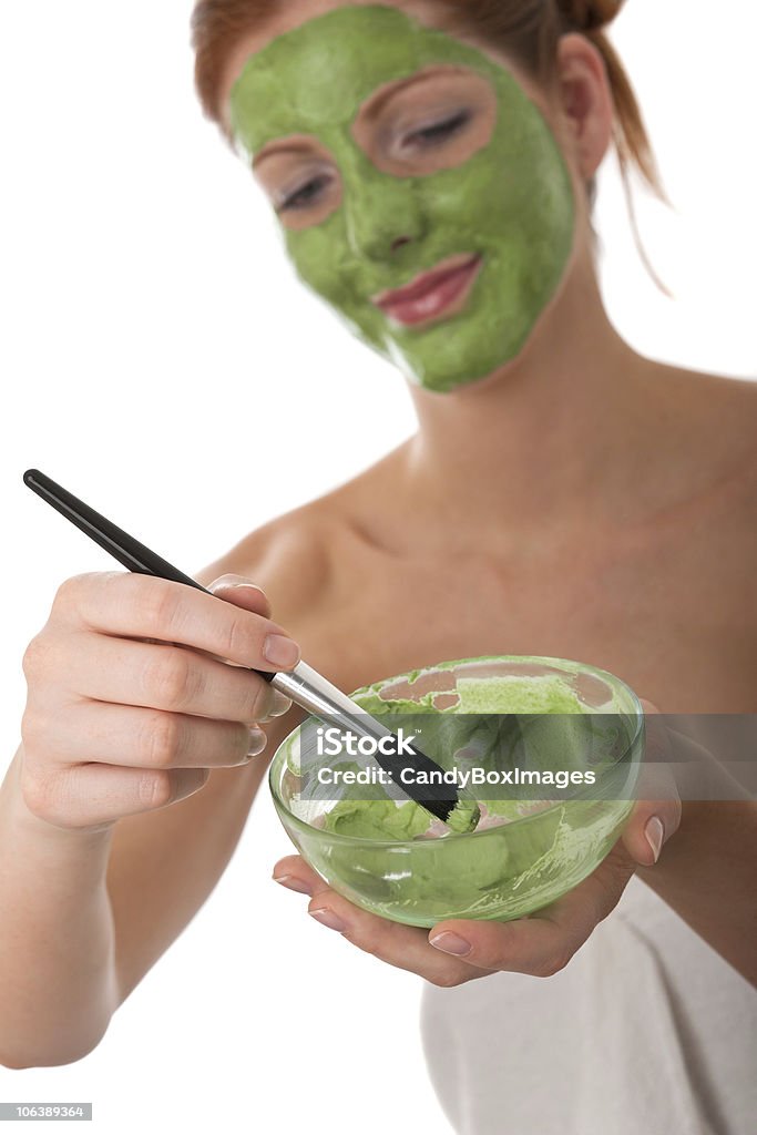 Body care series - Young woman applying green facial mask Young woman applying green facial mask, focus on bowl and brush Adult Stock Photo