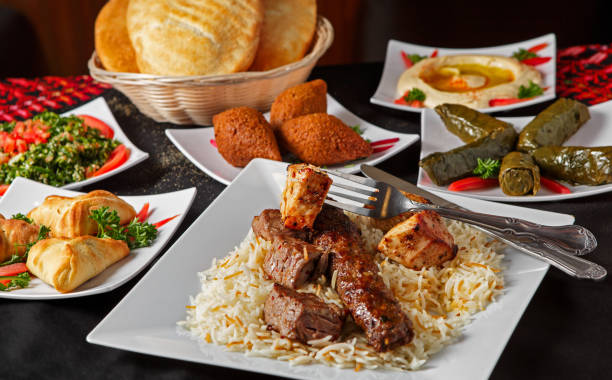 Lebanese Food Entree with Side Dishes Chicken and Beef Kabobs on Rice with Naan Bread and Side Dishes lebanese culture stock pictures, royalty-free photos & images