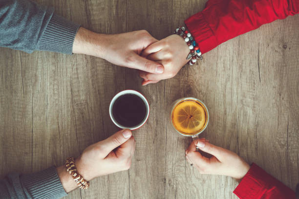 istock Couple holding hands and drinking tea 1063894978