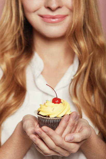 istock Woman hands holding a delicious yummy cupcake 1063895196
