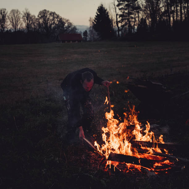 istock Man burning wood waste outdoors in evening disposal of burnable waste 1063896258