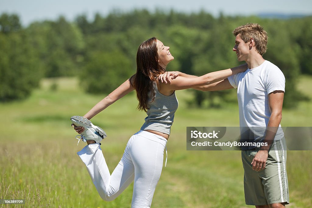 Verano para trotar-Pareja joven de estiramiento en la soleada naturaleza - Foto de stock de Actividad libre de derechos