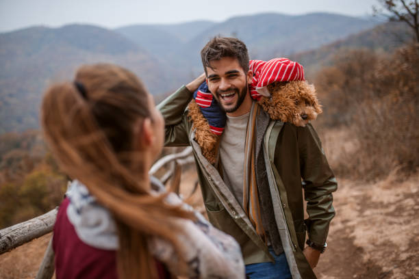 istock Man standing with dog on his shoulders and talking to his girlfriend. Selective focus on man. 1063897566