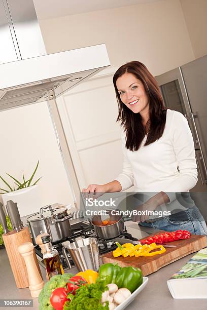 Foto de Jovem Cozinhar Na Cozinha Molho De Tomate e mais fotos de stock de Adulto - Adulto, Beleza, Caderno de Receitas