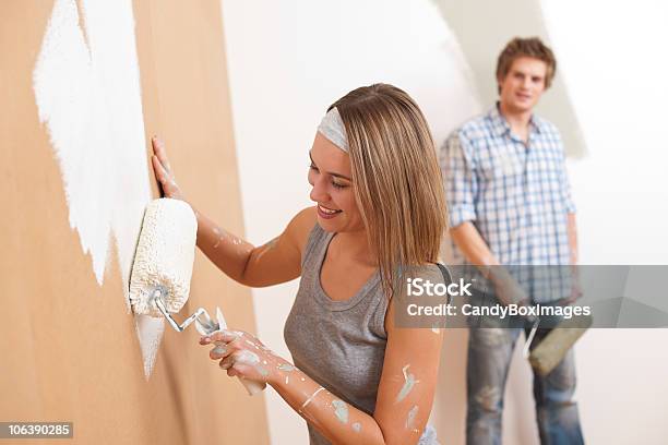 Casa Mejora Hombre Joven Y Mujer Pintura De Pared Foto de stock y más banco de imágenes de Adulto - Adulto, Adulto joven, Alegre