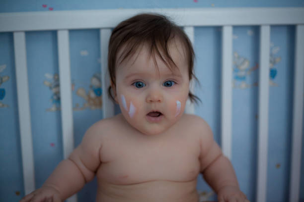 istock Adorable baby with face cream. 1063903004