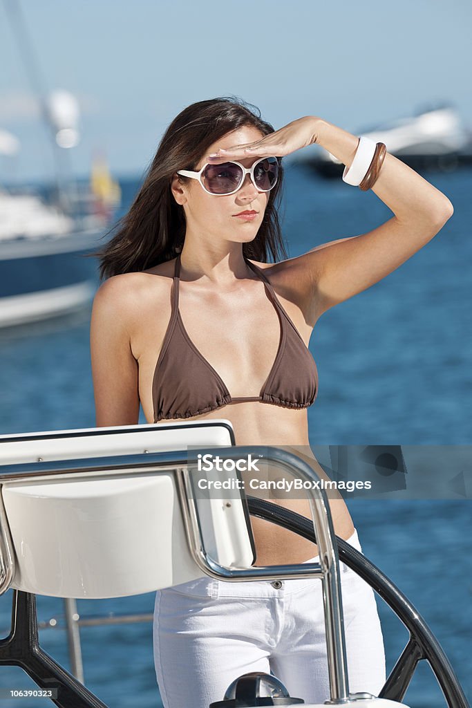 Giovane donna vela su uno yacht di lusso - Foto stock royalty-free di Abbronzarsi