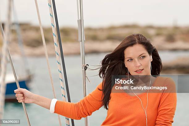 Attraente Donna In Piedi Sulla Barca A Vela Con Cuffie - Fotografie stock e altre immagini di Acqua