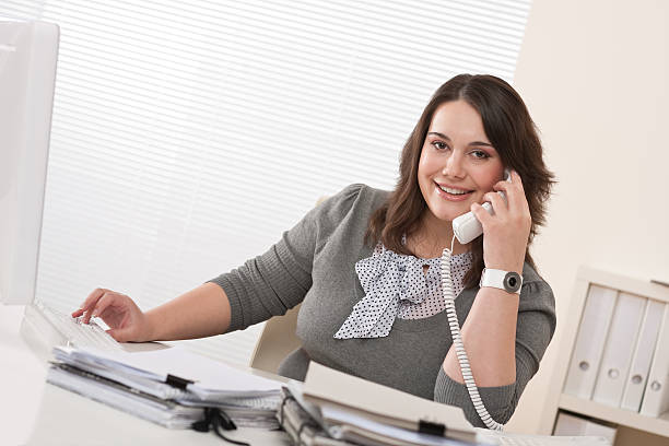 istock Smiling young woman using the telephone in a modern office  106390363