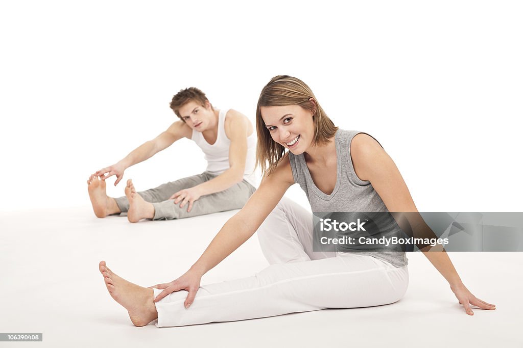 Sano Fitness-coppia, esercizi di stretching dopo l'allenamento su bianco - Foto stock royalty-free di Abbigliamento casual