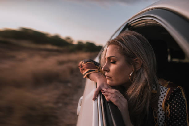 istock Young woman with eyes closed on car window 1063904622