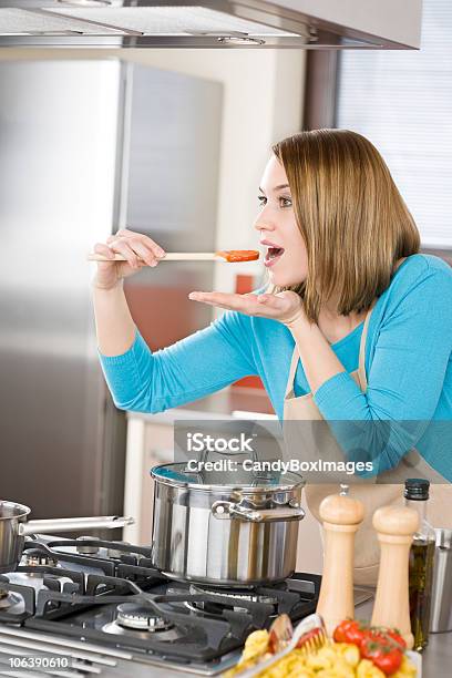 Foto de Mulher De Culinária E Degustação De Vinho Italiano Na Cozinha Moderna Com Molho De Tomate e mais fotos de stock de Mulheres