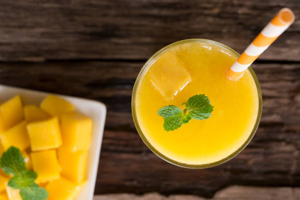 istock Mango smoothies colorful fruit juice milkshake blend beverage healthy high protein the yummy In glass drink to lose weight drink isolated wood background from the top view. 1063911192