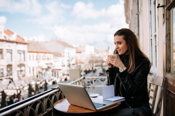 istock Cute girl drinking a cup of coffee on the balcony while studying. 1063913332