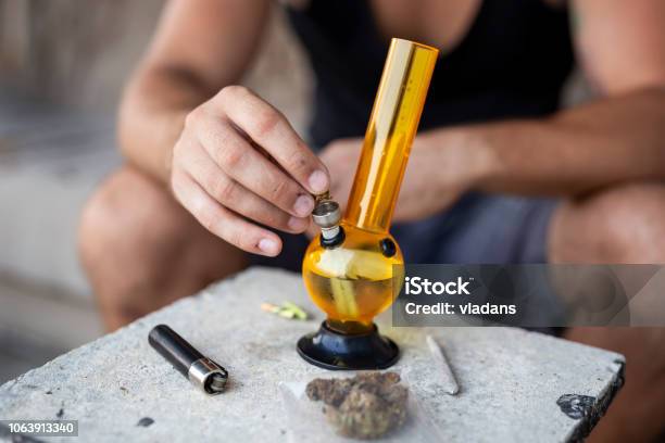 Man Filling Up Bong With Cannabis Stock Photo - Download Image Now - Bong, Smoking - Activity, Smoke - Physical Structure