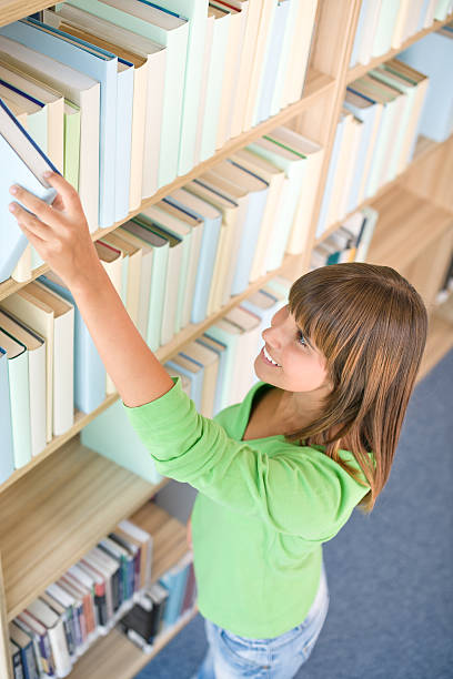 istock Student in library - happy woman choose book 106391339